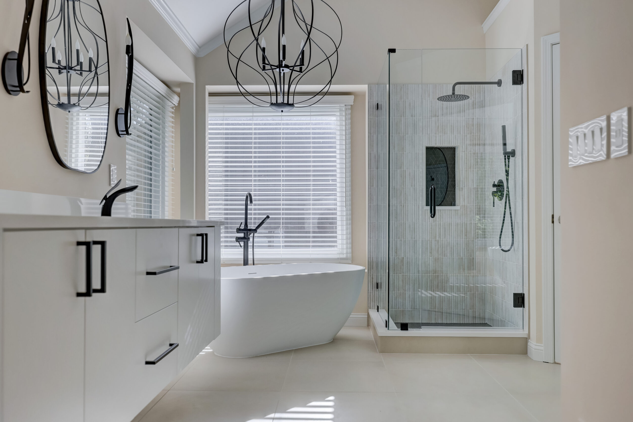 Luxury bathroom remodel with floating vanity, soaking tub, frameless glass shower, and matte black fixtures in West Bloomfield Michigan