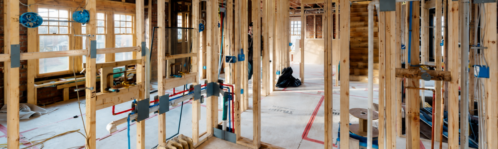 New framing, electrical wiring, plumbing rough-ins, and an original steam radiator during the complete renovation of a 1906 Detroit Tudor by Maxwell Building Services.