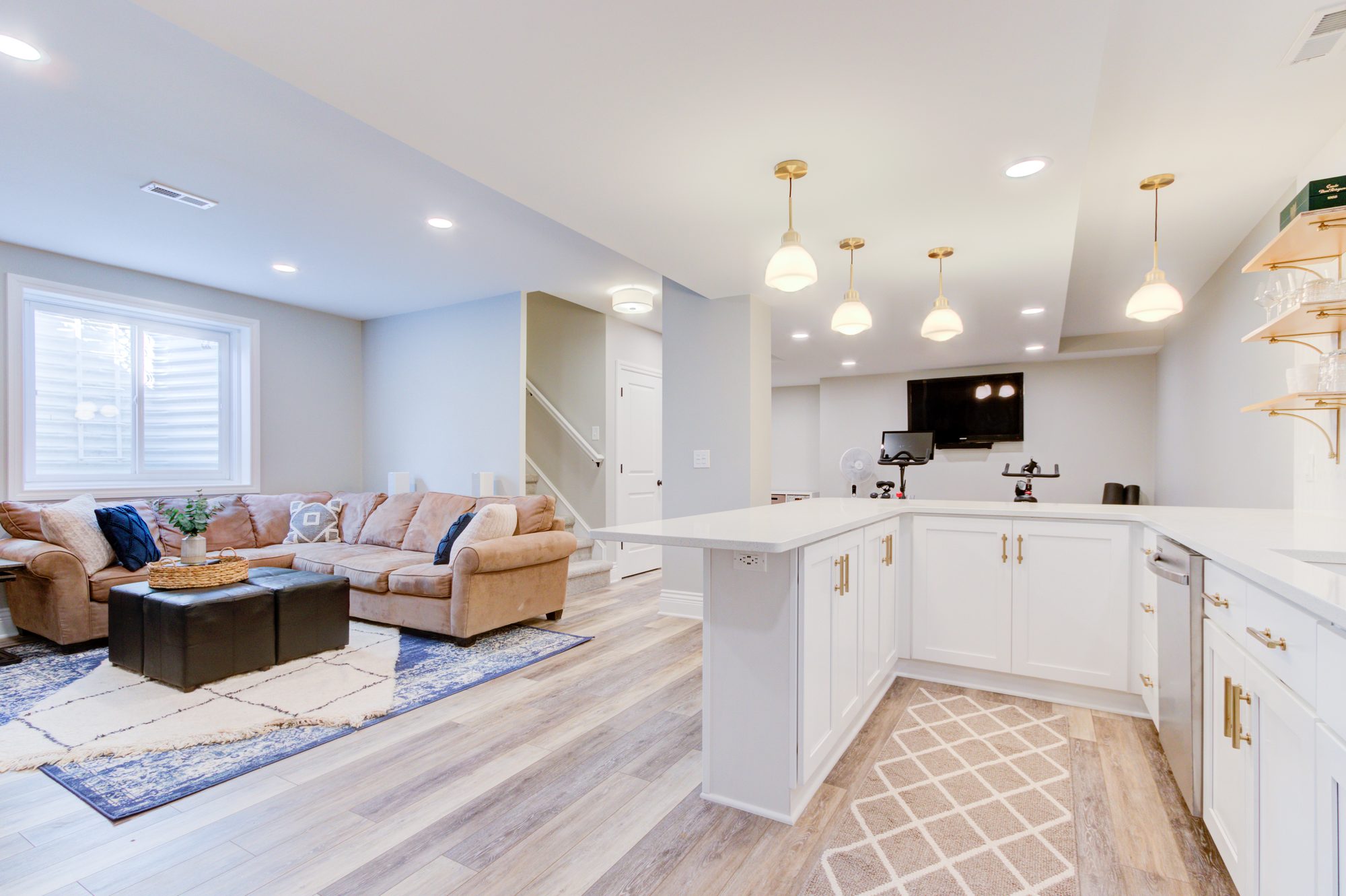 Open plan basement lounge looking toward the wet bar and kitchenette in a Birmingham MI basement remodel