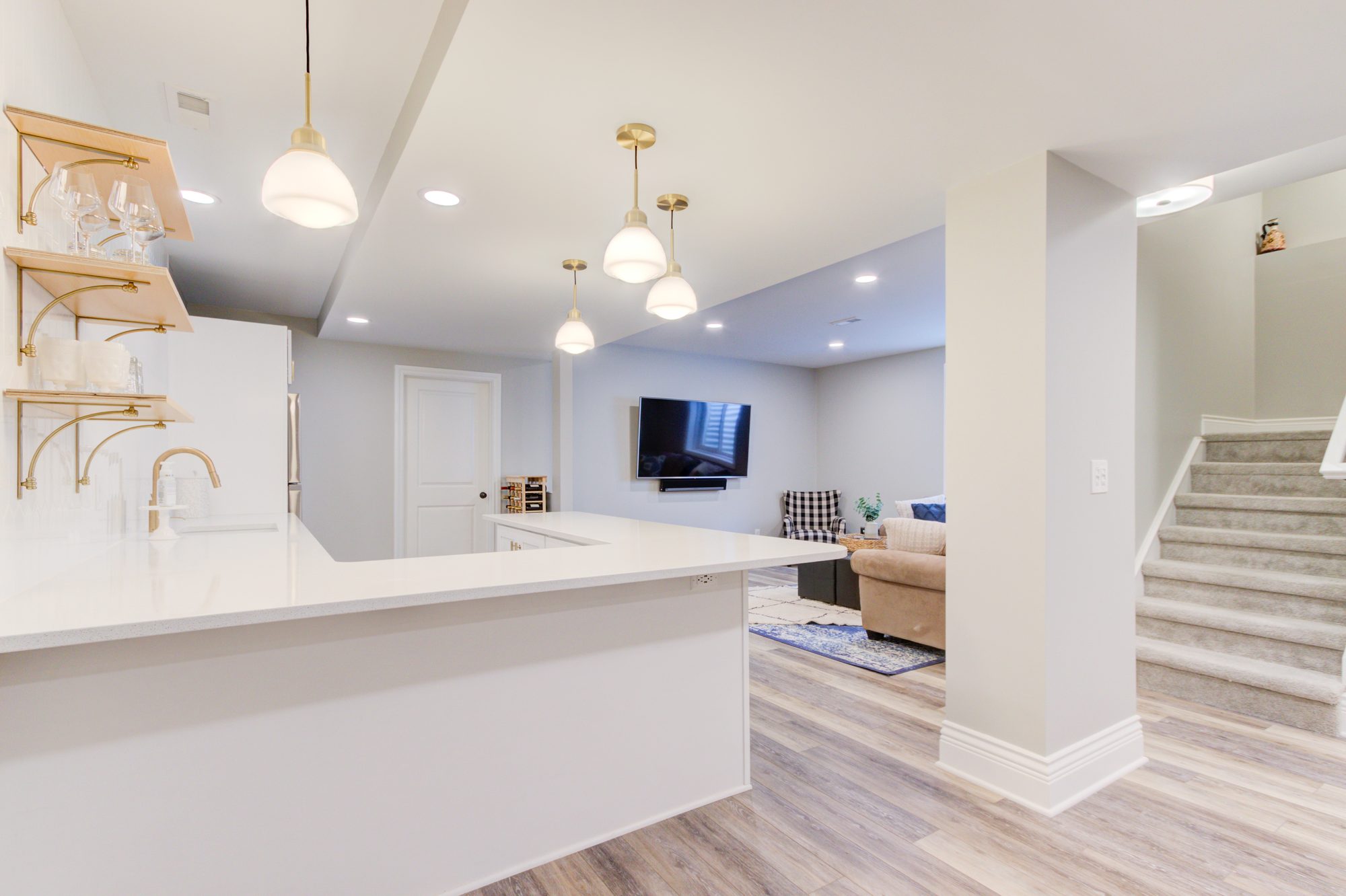 Quartz bar counter looking across to the media lounge and stairs in a Birmingham MI finished basement