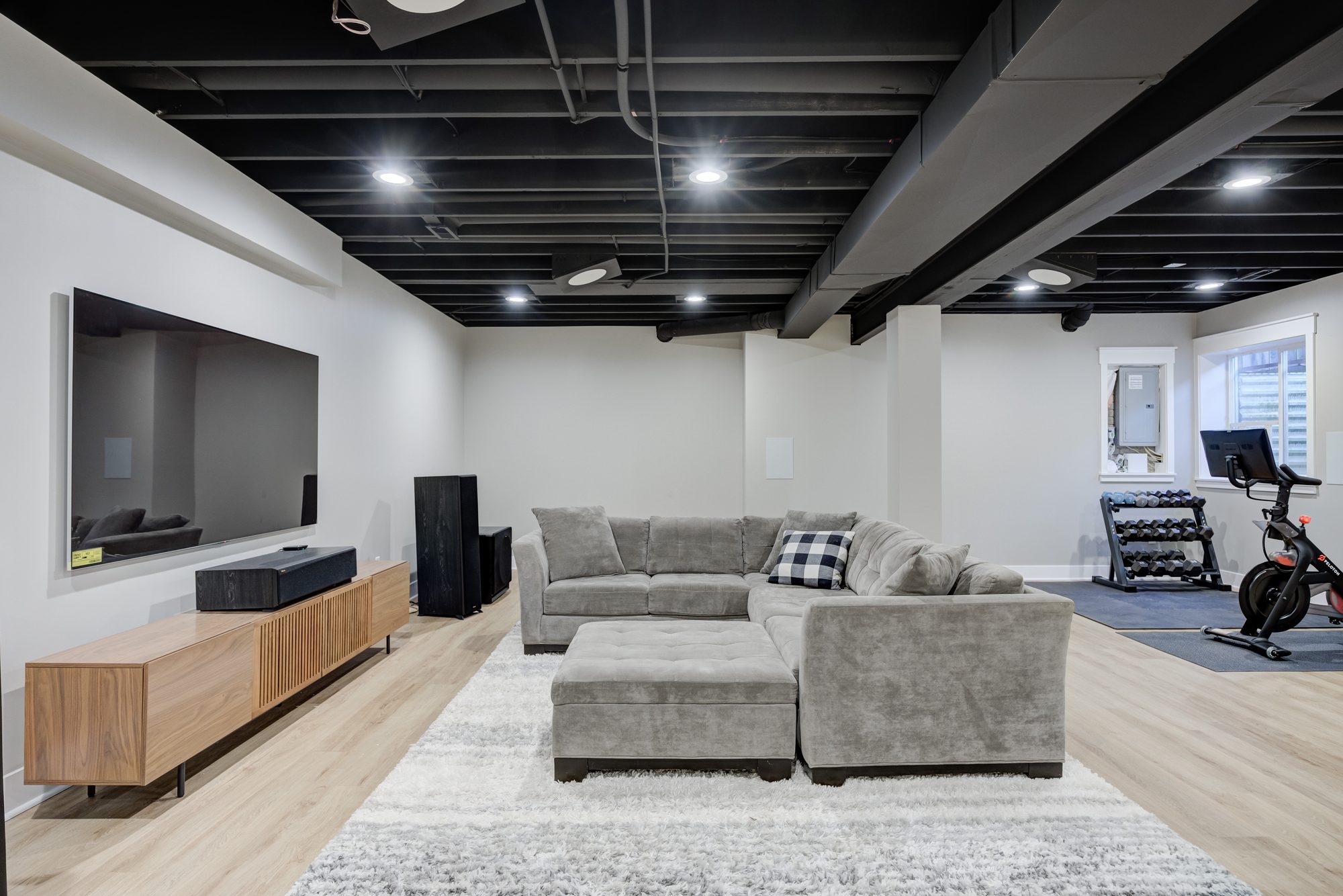 Media wall and sectional looking toward the home gym in a Royal Oak MI finished basement