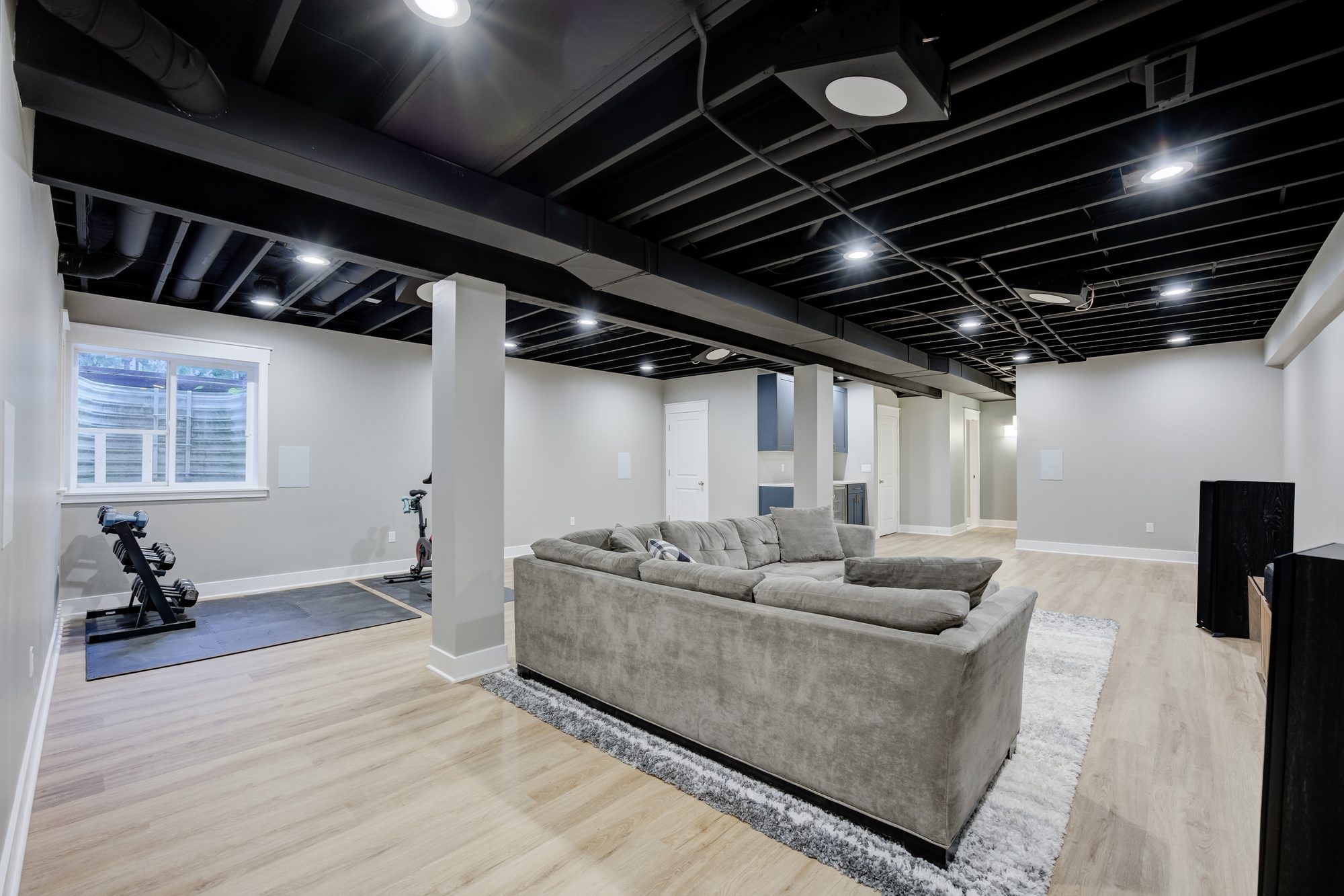 Home gym area with rubber flooring below a full size egress window in a Royal Oak MI finished basement
