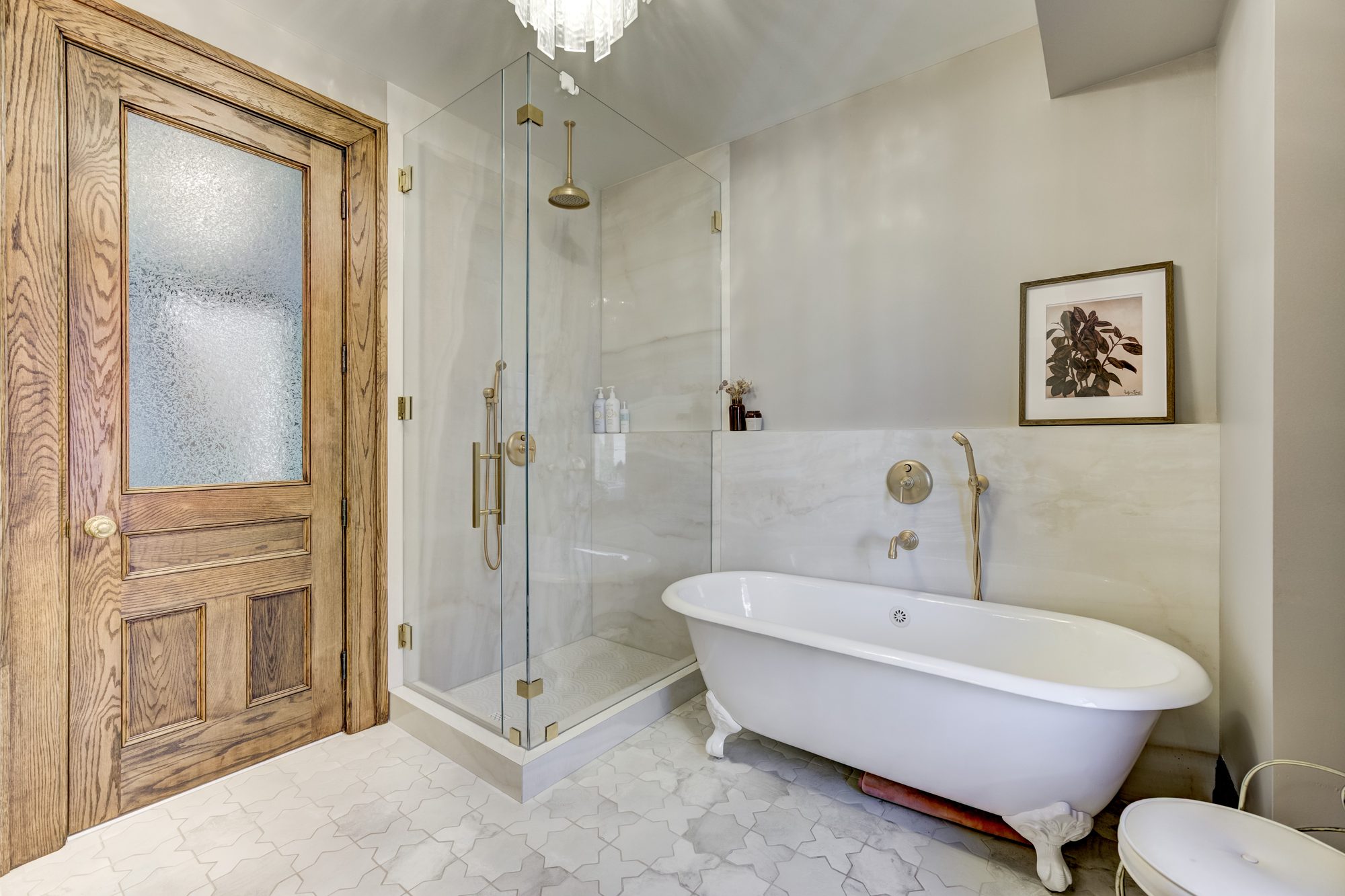 Corner glass shower with a brass rain head beside a clawfoot tub and restored oak door in a Birmingham MI bathroom