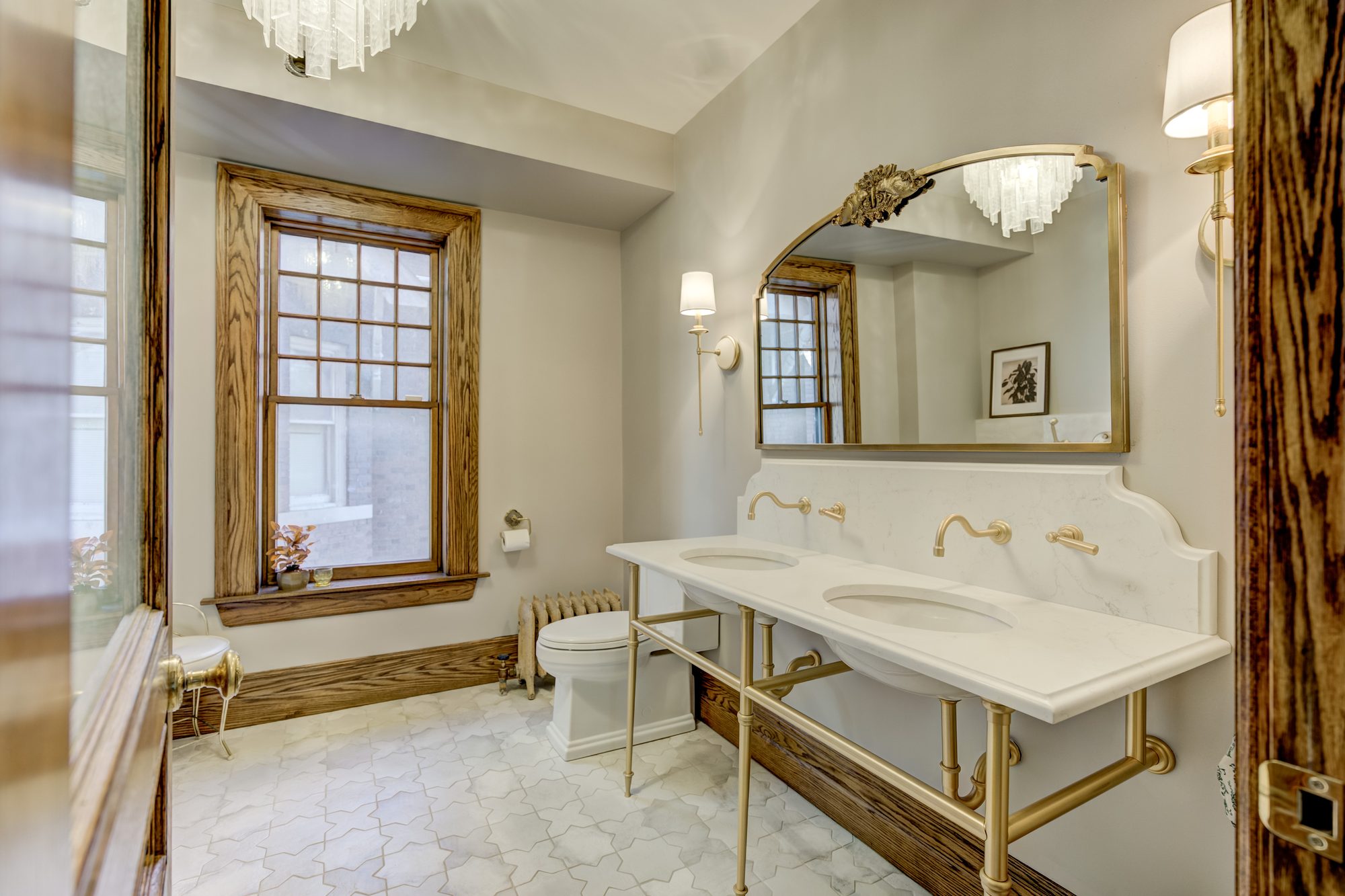 Vanity wall with restored original oak trim and the retained cast iron radiator in a Birmingham MI bathroom remodel