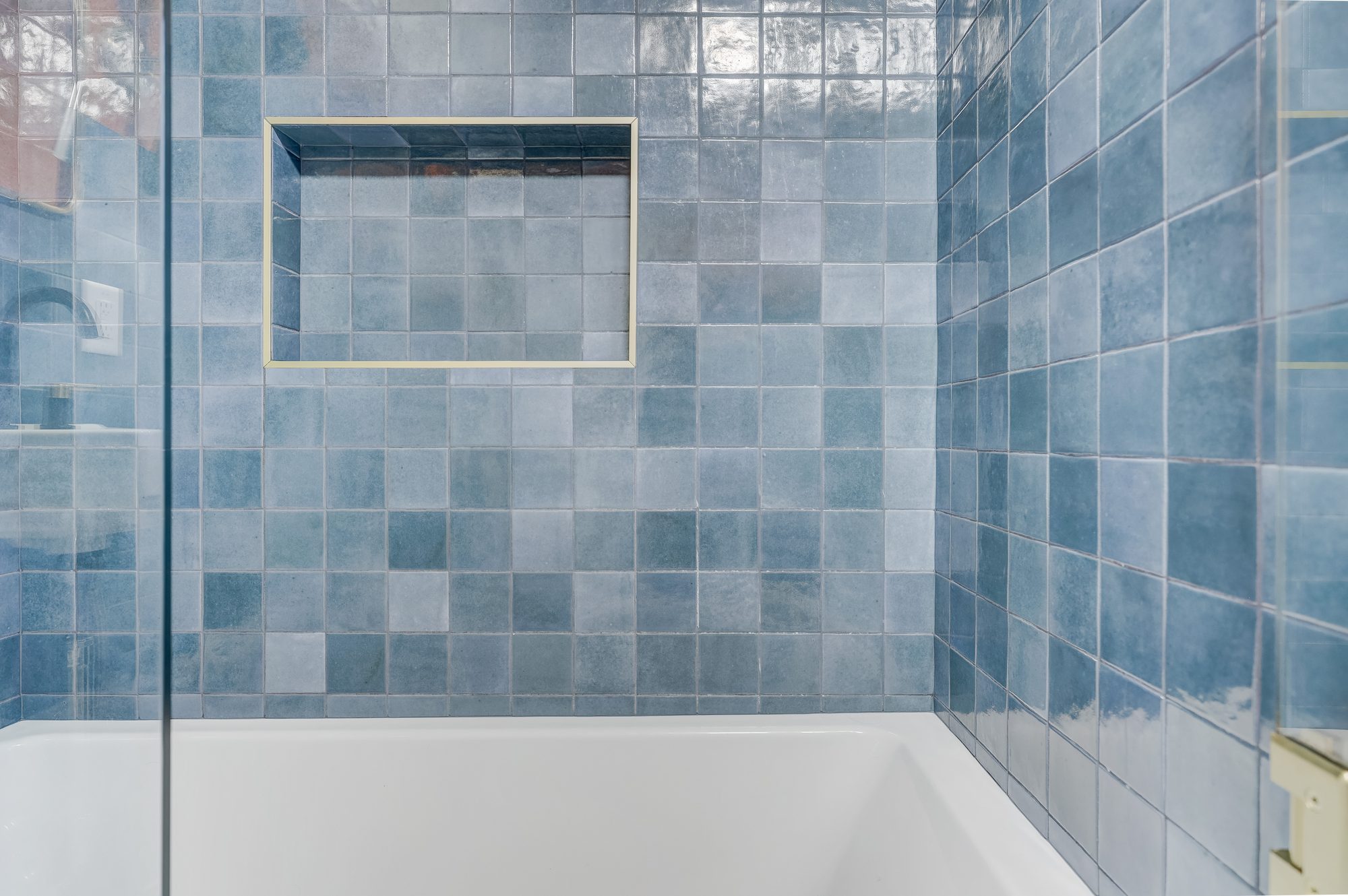 Blue zellige tile tub surround with a brass framed niche in a Ferndale MI bathroom remodel