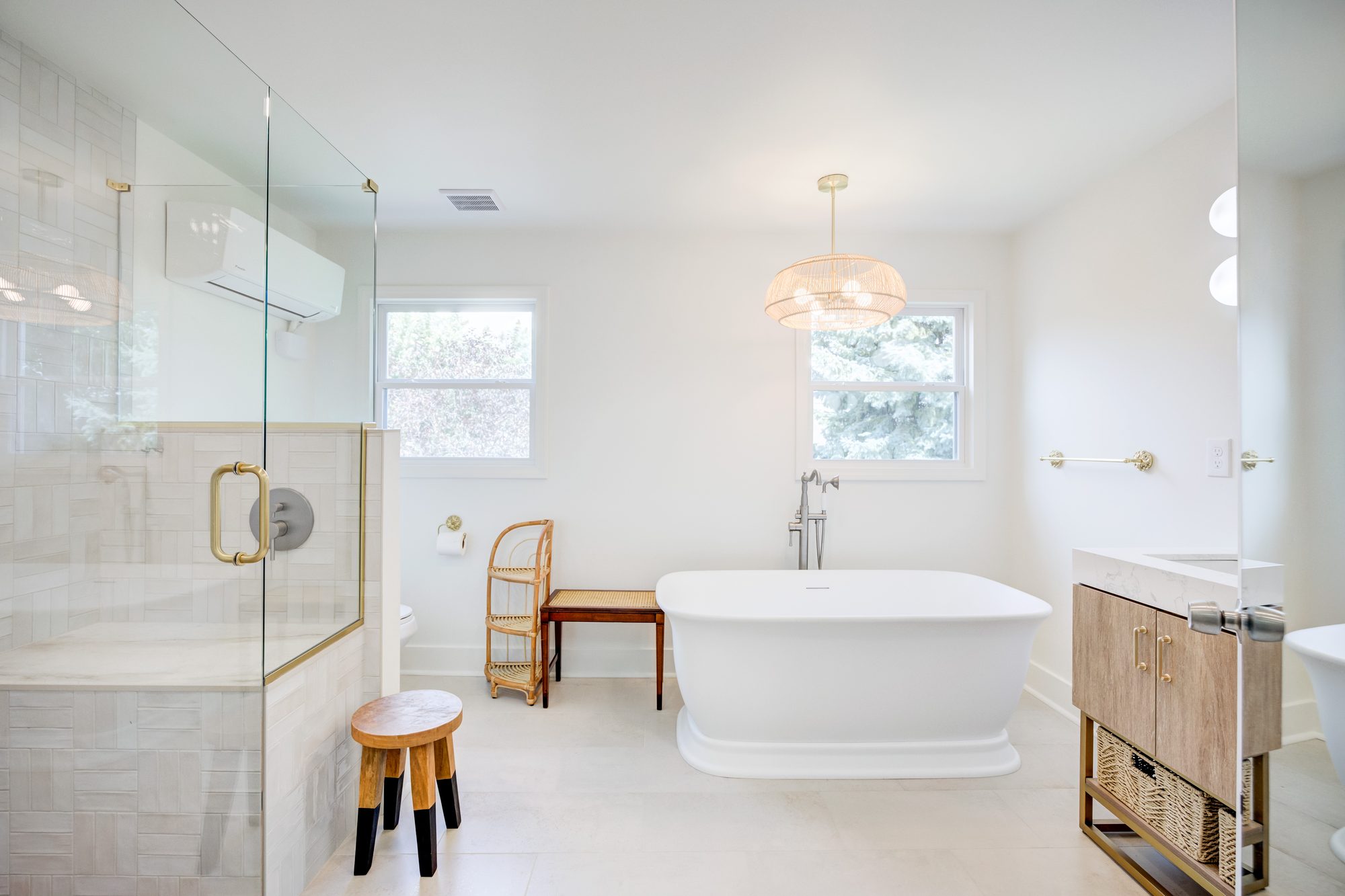 Remodeled bathroom in Huntington Woods MI with a freestanding tub, handmade tile shower and rattan chandelier
