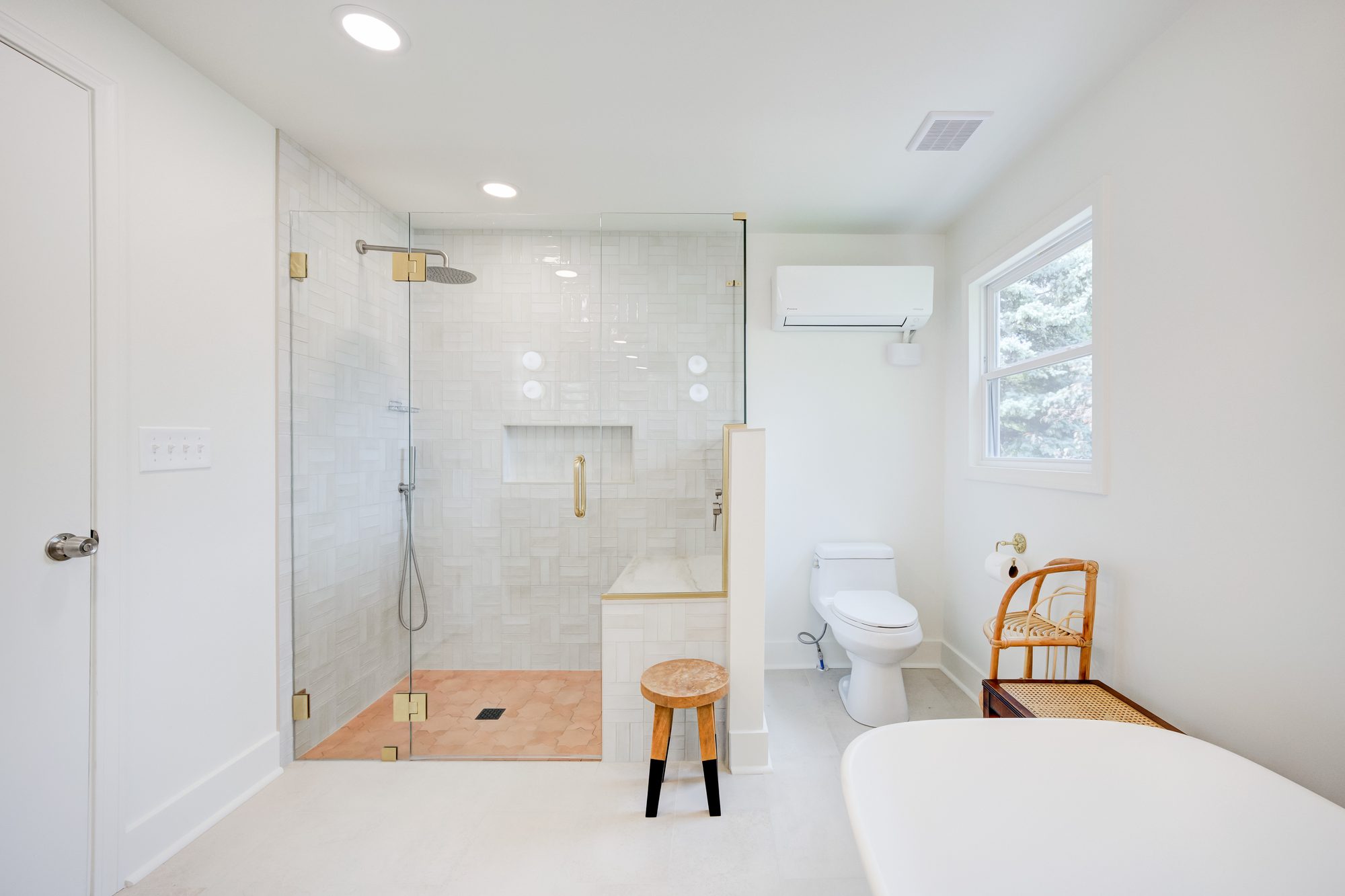 View from the doorway to the walk in shower and freestanding tub in a Huntington Woods MI bathroom remodel