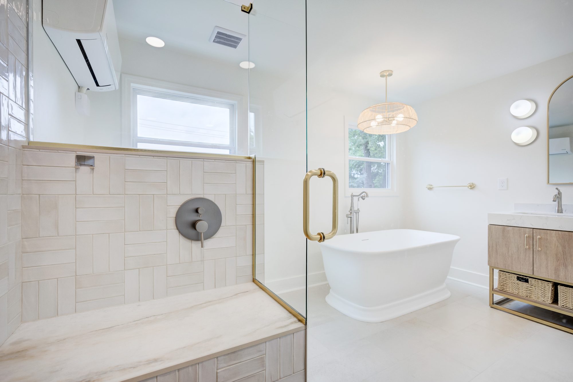 Marble shower bench looking out to the freestanding tub and vanity in a Huntington Woods MI bathroom