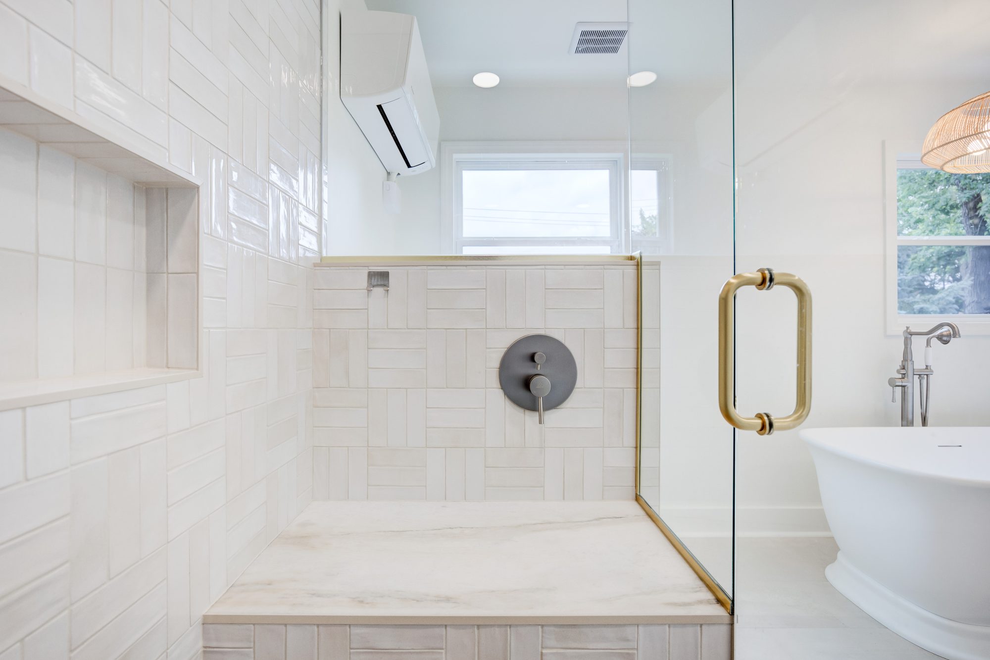 Marble shower bench with brass edge trim against handmade basketweave tile in a Huntington Woods MI bathroom