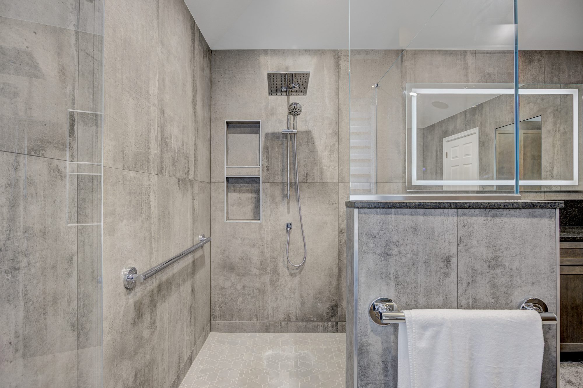 Zero threshold shower with a grab bar, built in niche and rain head in a Troy MI bathroom remodel