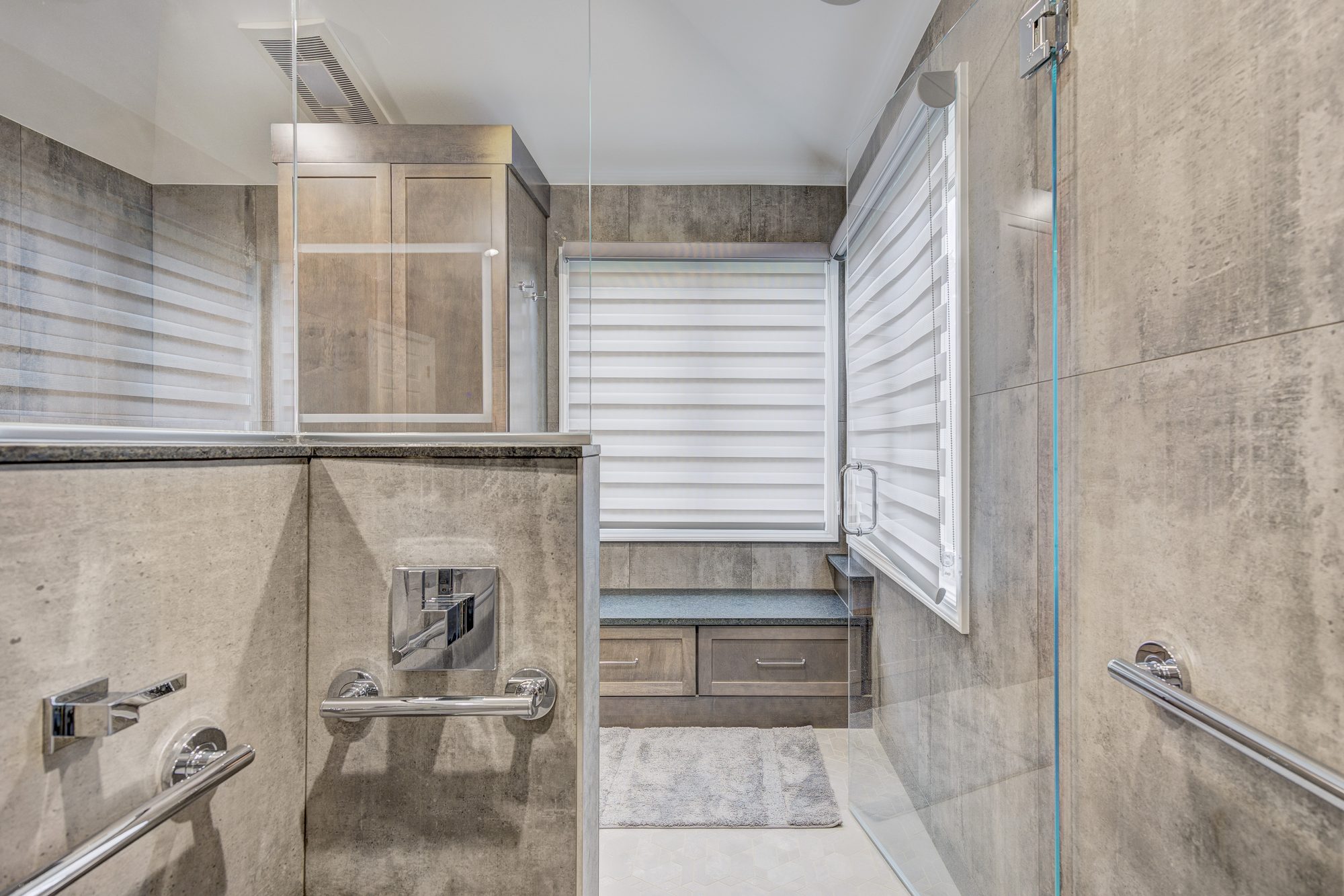 Thermostatic shower valve and grab bars inside the curbless shower in a Troy MI bathroom remodel