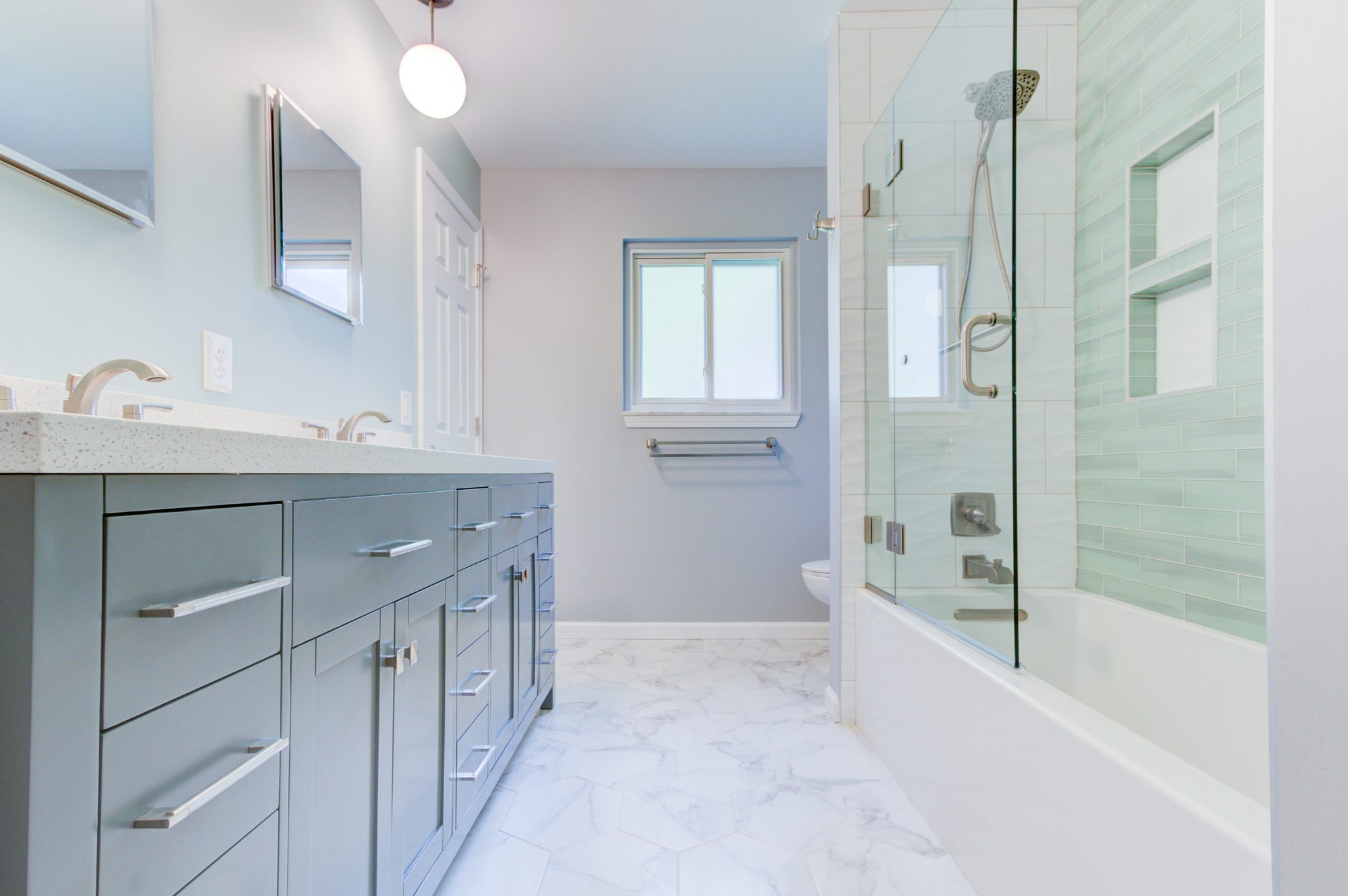 Double vanity with a quartz counter looking toward the tub and shower in a Troy MI bathroom remodel
