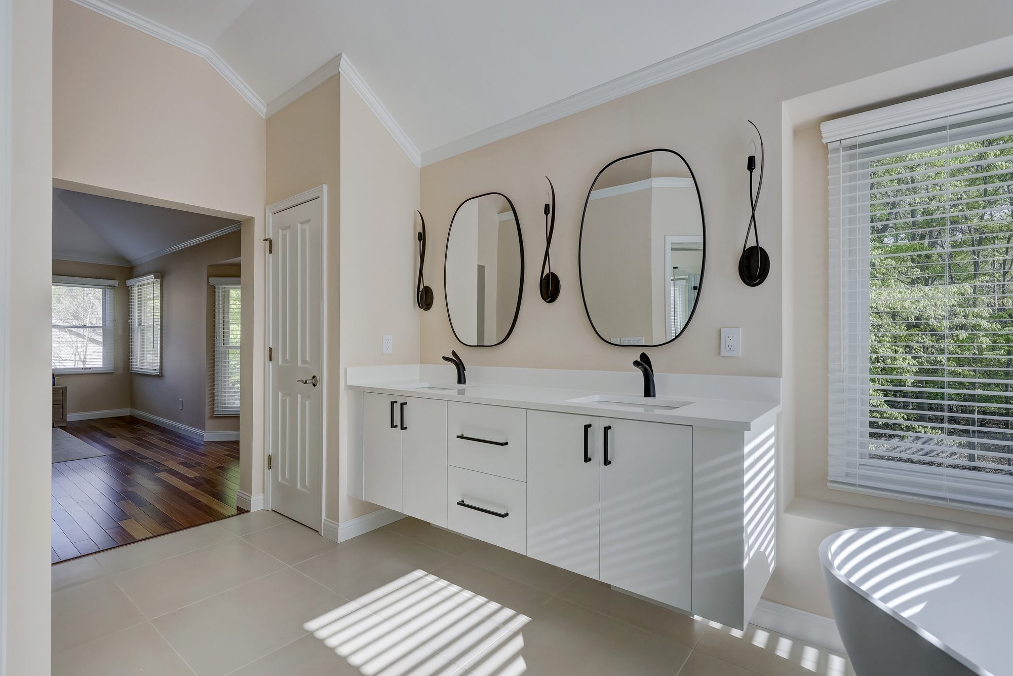 Fluted white vanity with a quartz counter looking toward the bedroom in a West Bloomfield MI bathroom remodel