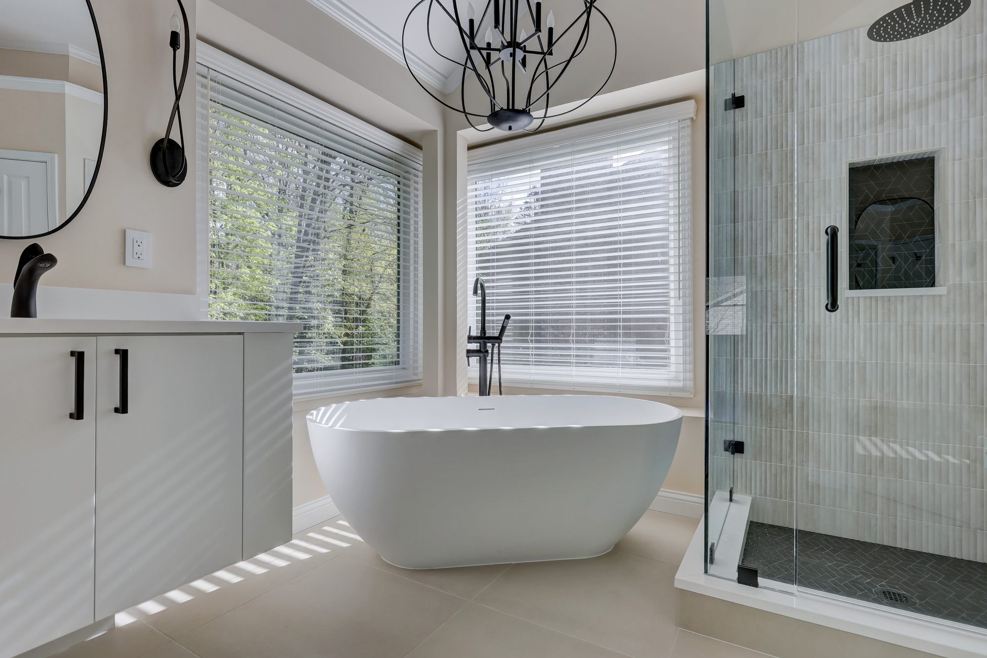 Soaking tub beside the frameless corner glass shower in a West Bloomfield MI primary bathroom
