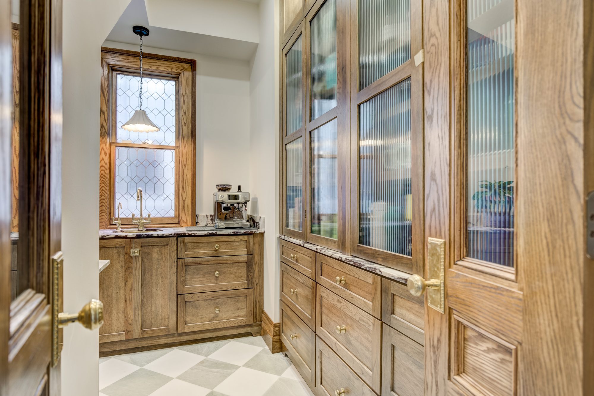 Full height reeded glass cabinet run with brass knobs and bin pulls in a Birmingham MI butler pantry