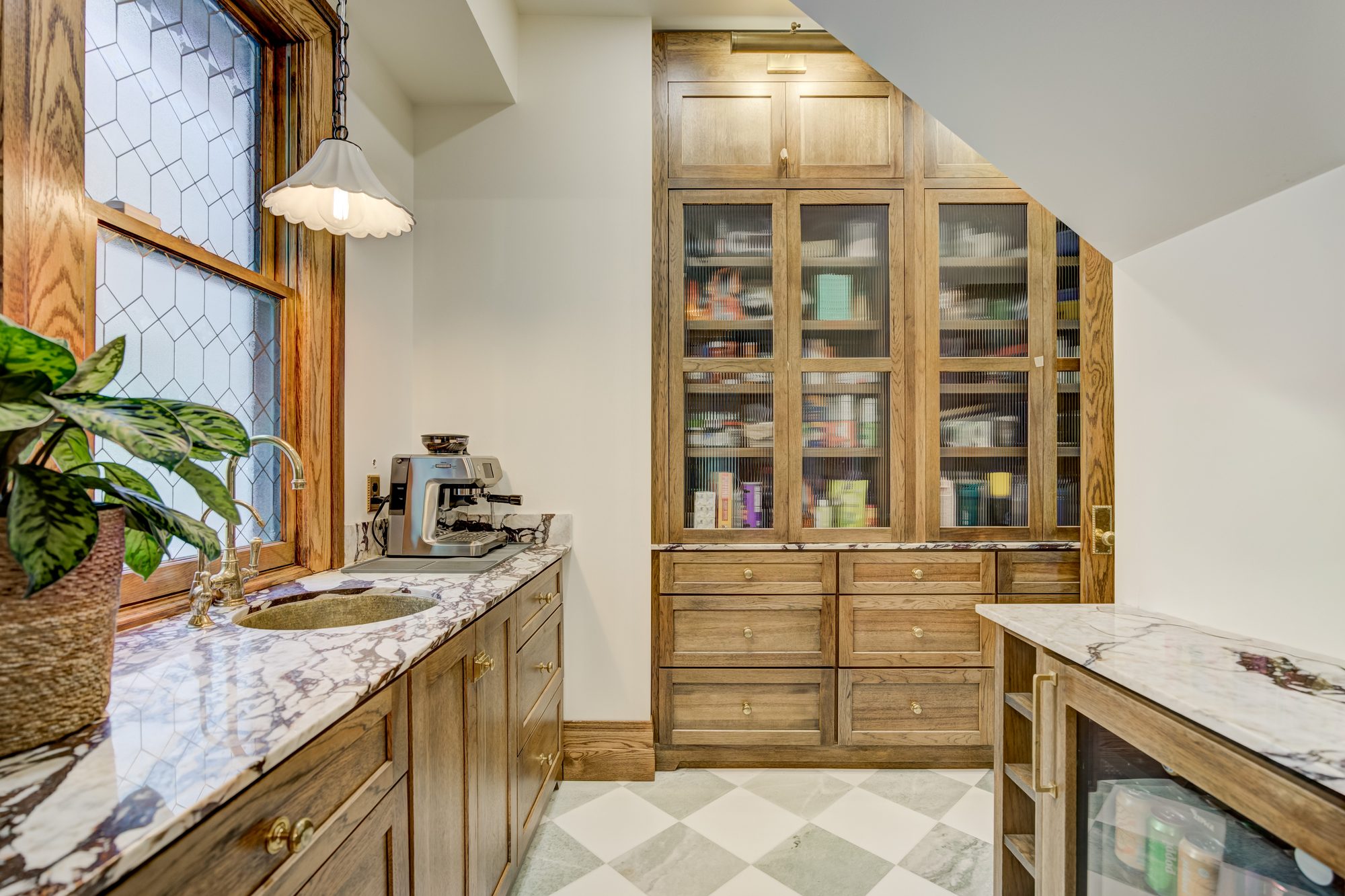 Floor to ceiling pantry storage built into the space under the stair in a Birmingham MI butler pantry