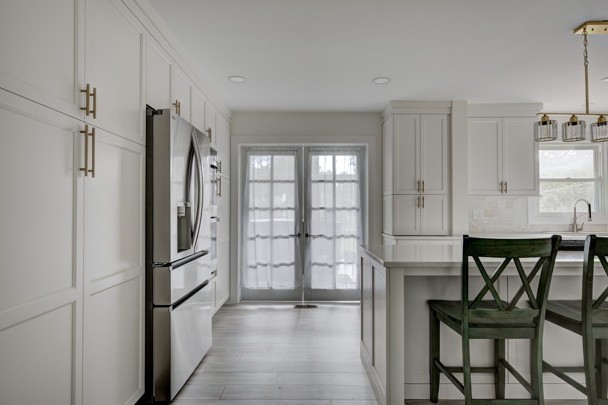 Floor to ceiling cabinet wall with integrated appliances beside french doors in a Beverly Hills MI kitchen
