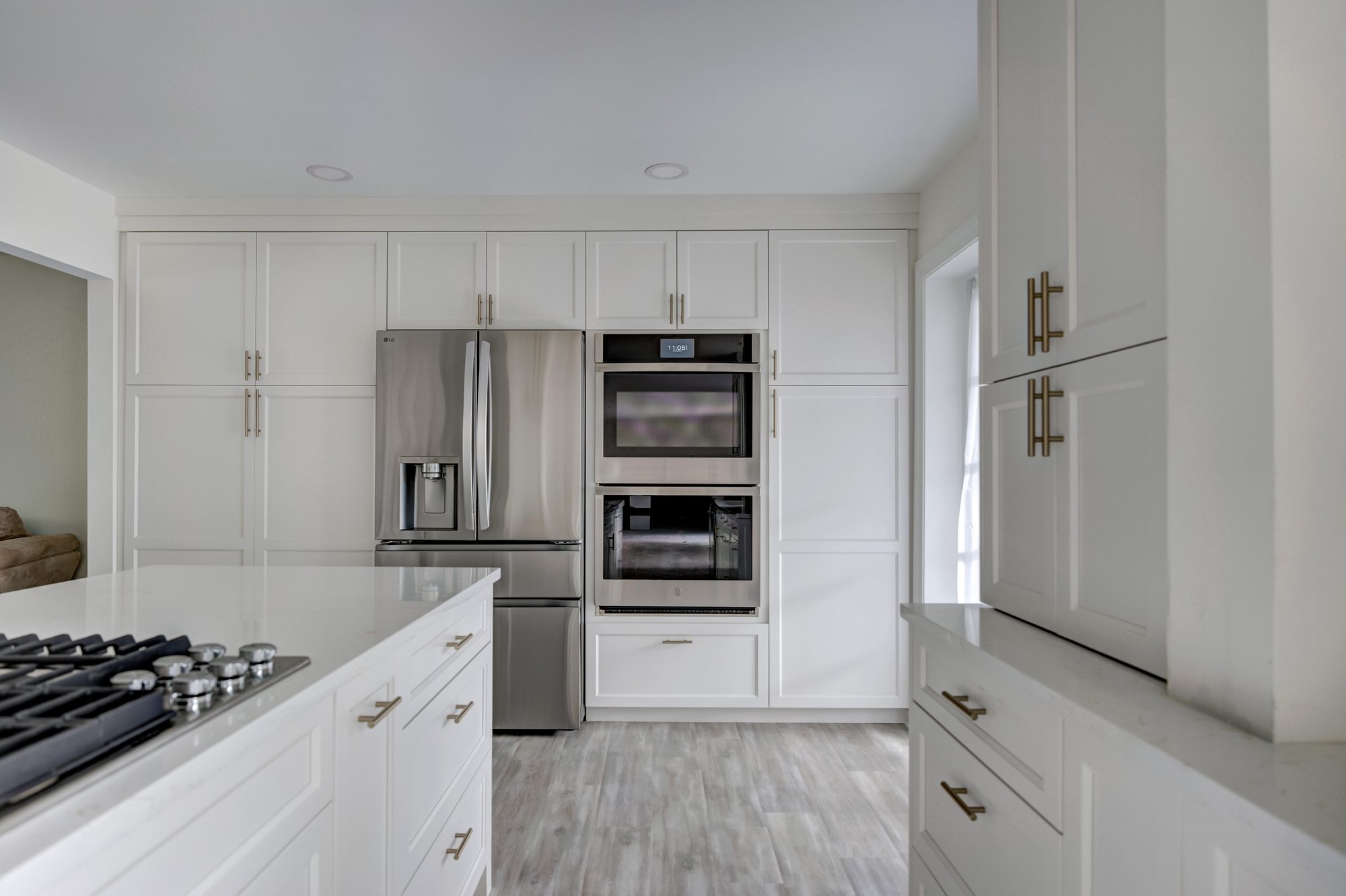Paneled cabinet wall with a built in refrigerator and stainless double wall ovens in a Beverly Hills MI kitchen