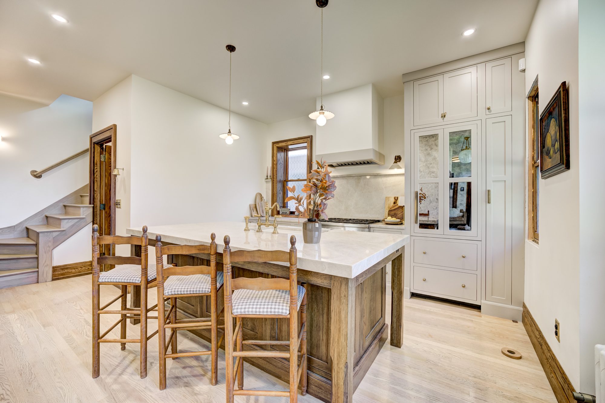 Island seating with ladder back stools and schoolhouse pendants in a Birmingham MI kitchen remodel