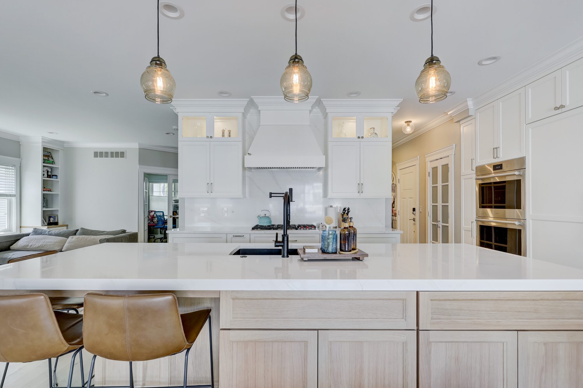 View across the quartz island toward the custom range hood in a Birmingham MI kitchen remodel