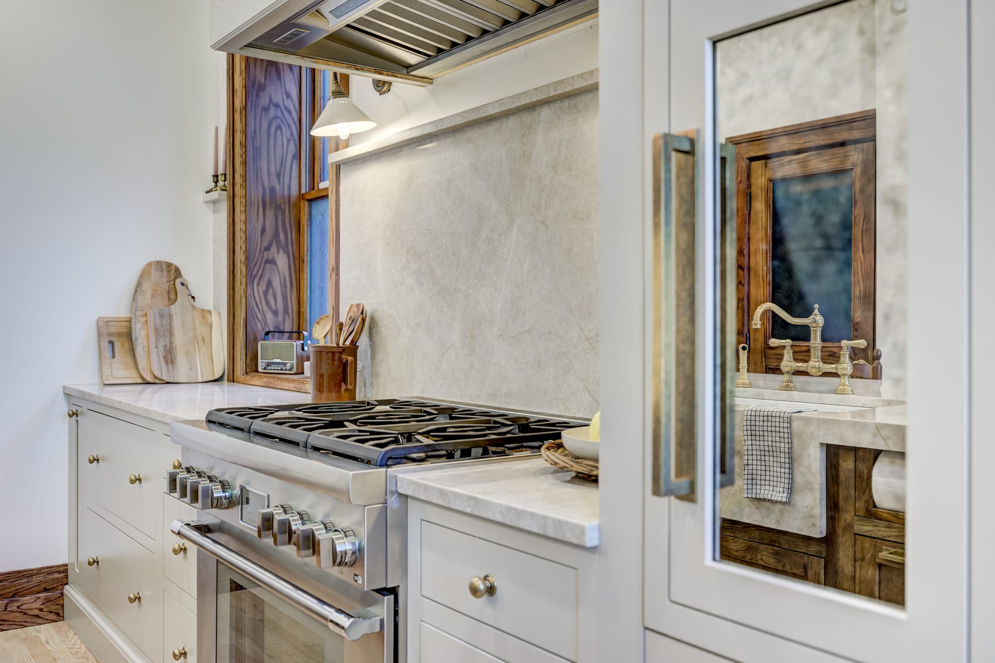 Island sink looking toward the restored original oak doors and textured glass in a Birmingham MI kitchen