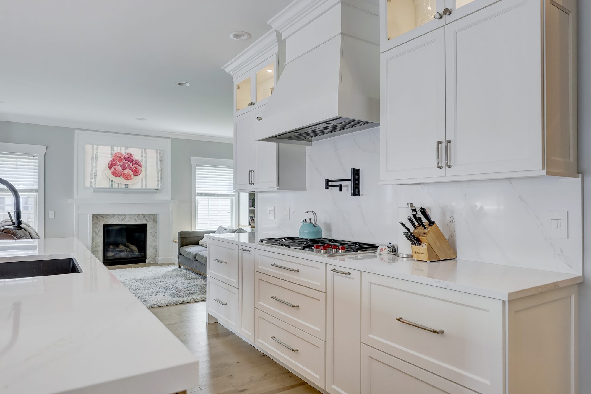 Full height quartz slab backsplash above a gas cooktop in a Birmingham MI kitchen remodel