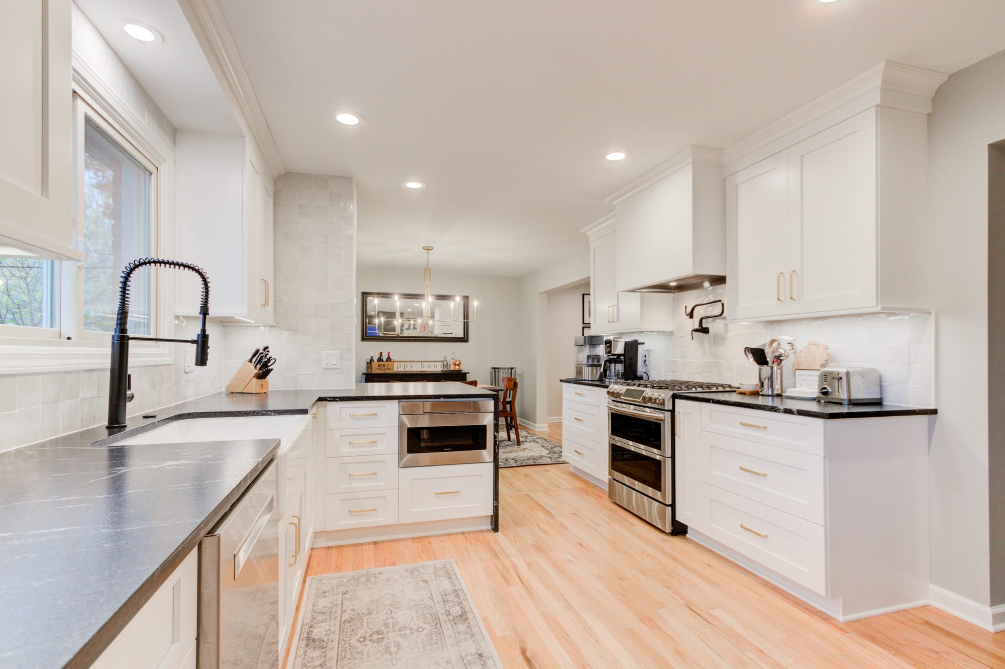 Remodeled Bloomfield Hills MI kitchen with white shaker cabinets, honed black granite counters and a white zellige backsplash
