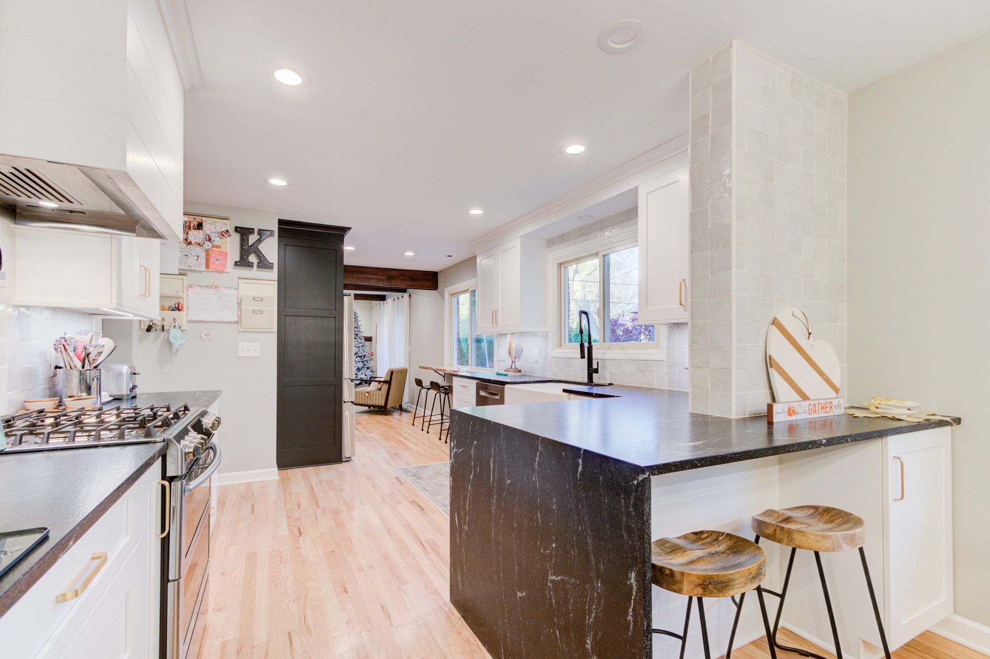 Granite peninsula with a waterfall end panel and counter stools in a Bloomfield Hills MI kitchen remodel