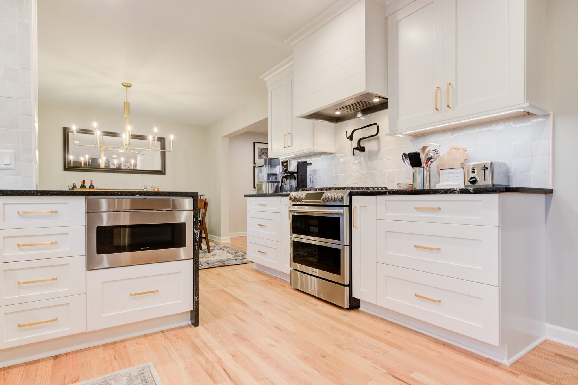 Built in microwave drawer and range wall looking toward the dining room in a Bloomfield Hills MI kitchen remodel