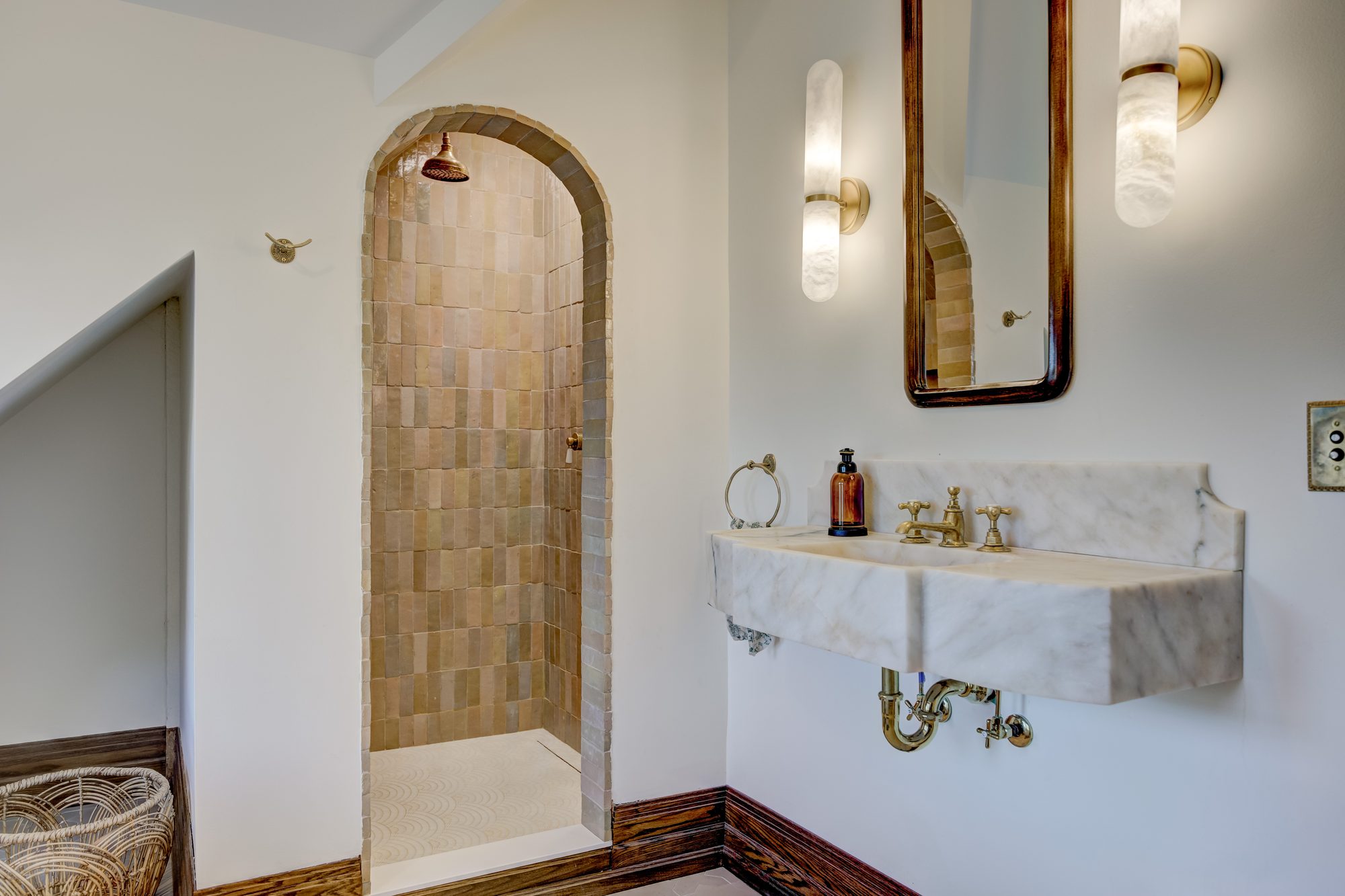Doorless arched shower with a brass rain head and handmade zellige tile in a Birmingham MI master bathroom