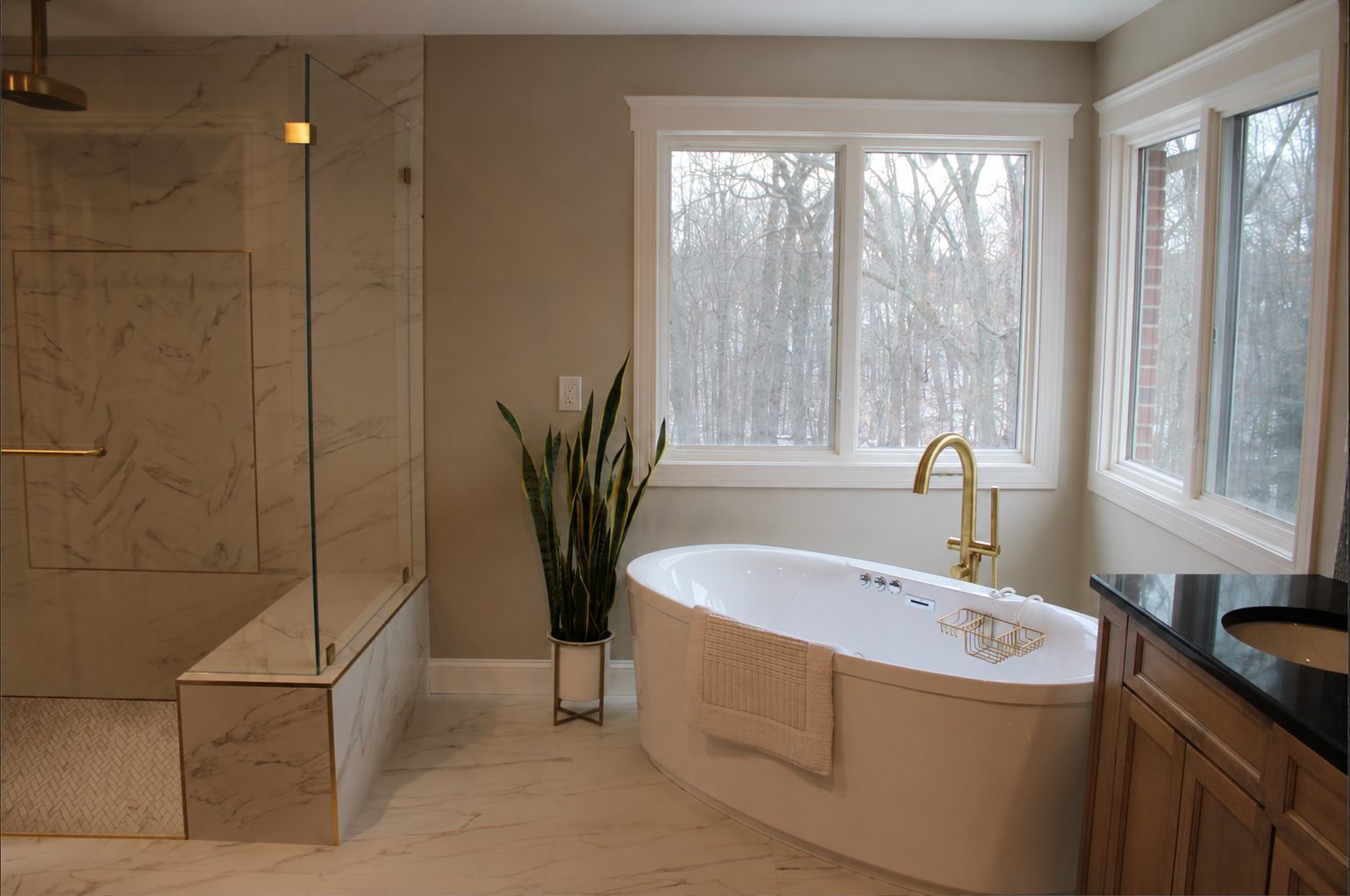 Marble look shower with a built in bench beside the freestanding tub and double vanity in a Rochester Hills MI bathroom