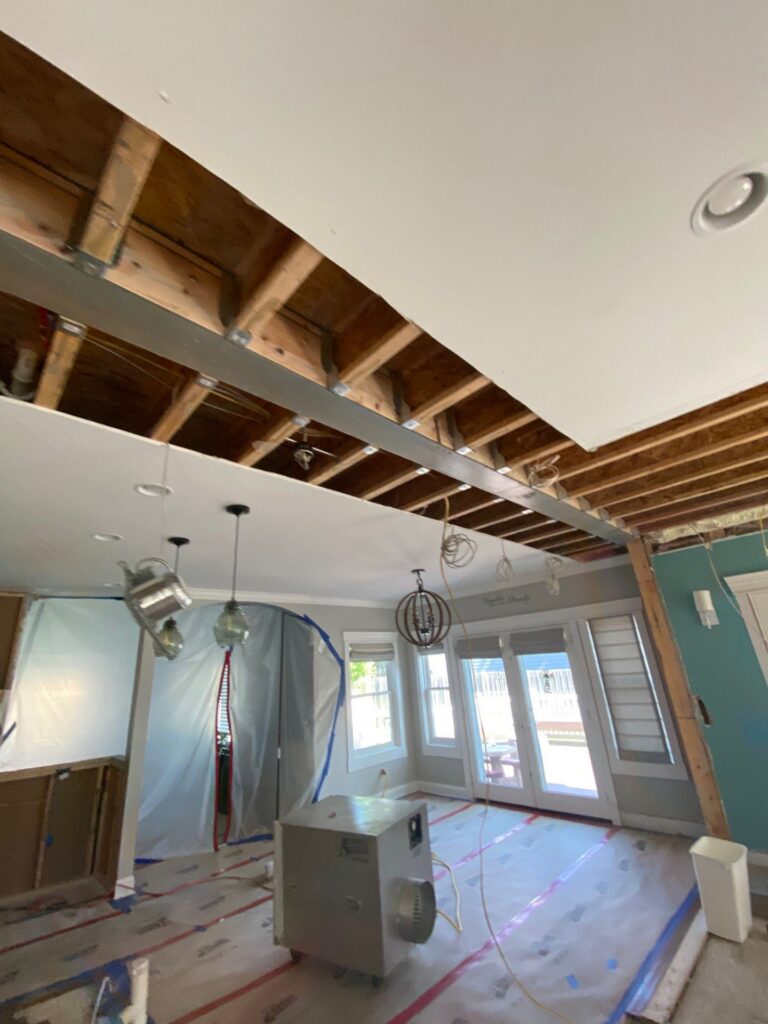 Steel I beam in the ceiling with joist hangers, plastic dust walls, floor protection and a HEPA air scrubber in a Birmingham MI home