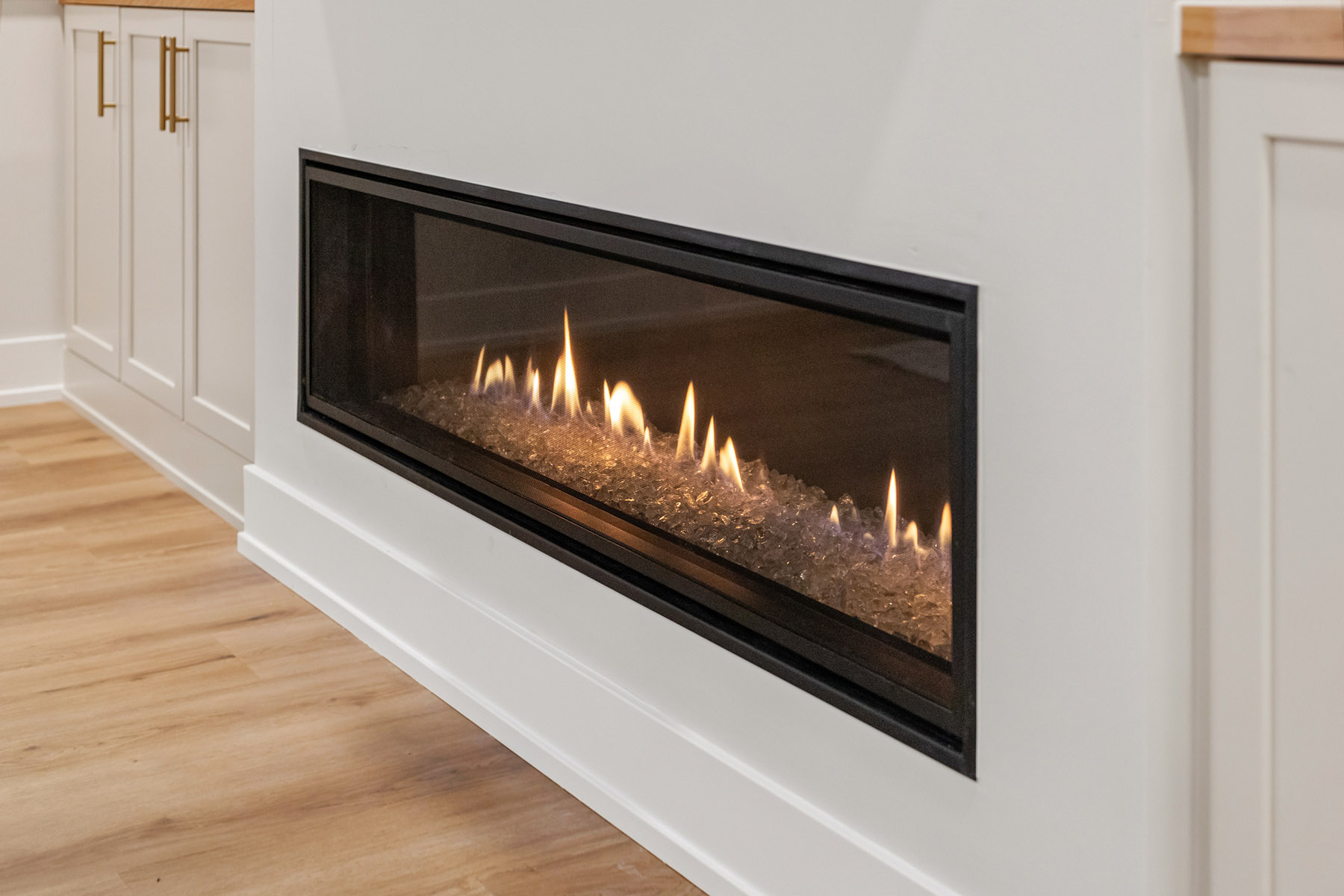Close view of the linear gas fireplace set into a white built in wall