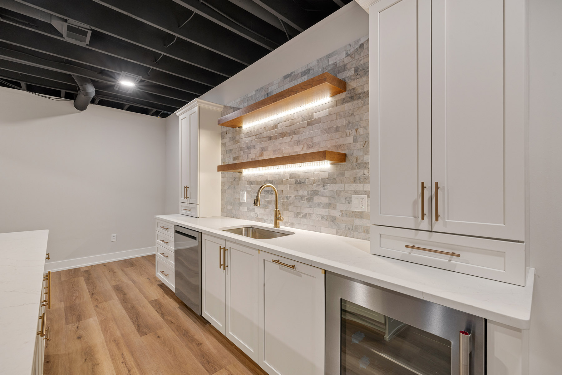 Bar cabinetry run with dishwasher, beverage refrigerator and quartz countertops